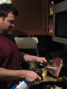 Me, with thing-what-burns.  90% of this particular experiment was probably inspired by the opportunity to blowtorch meat in the kitchen with impunity. 